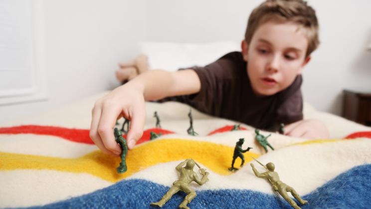 Young boy plays with toy soldiers